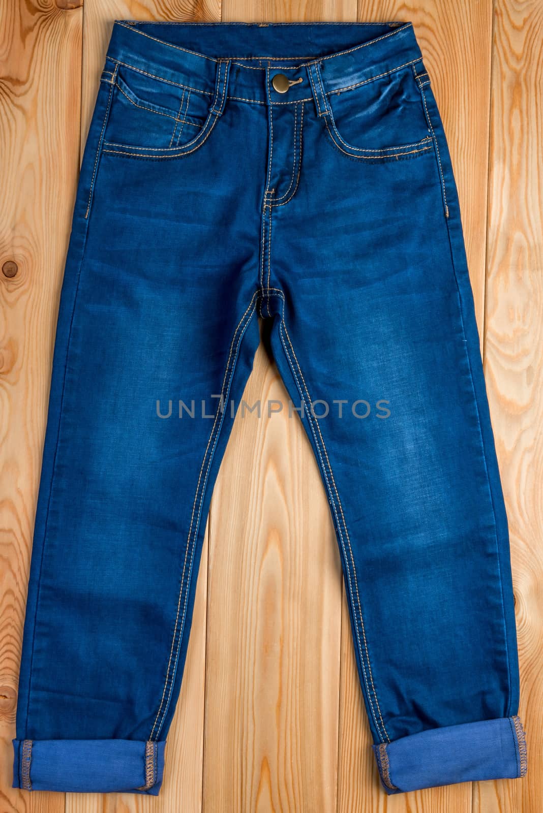 dark blue jeans for a boy on a wooden floor top view