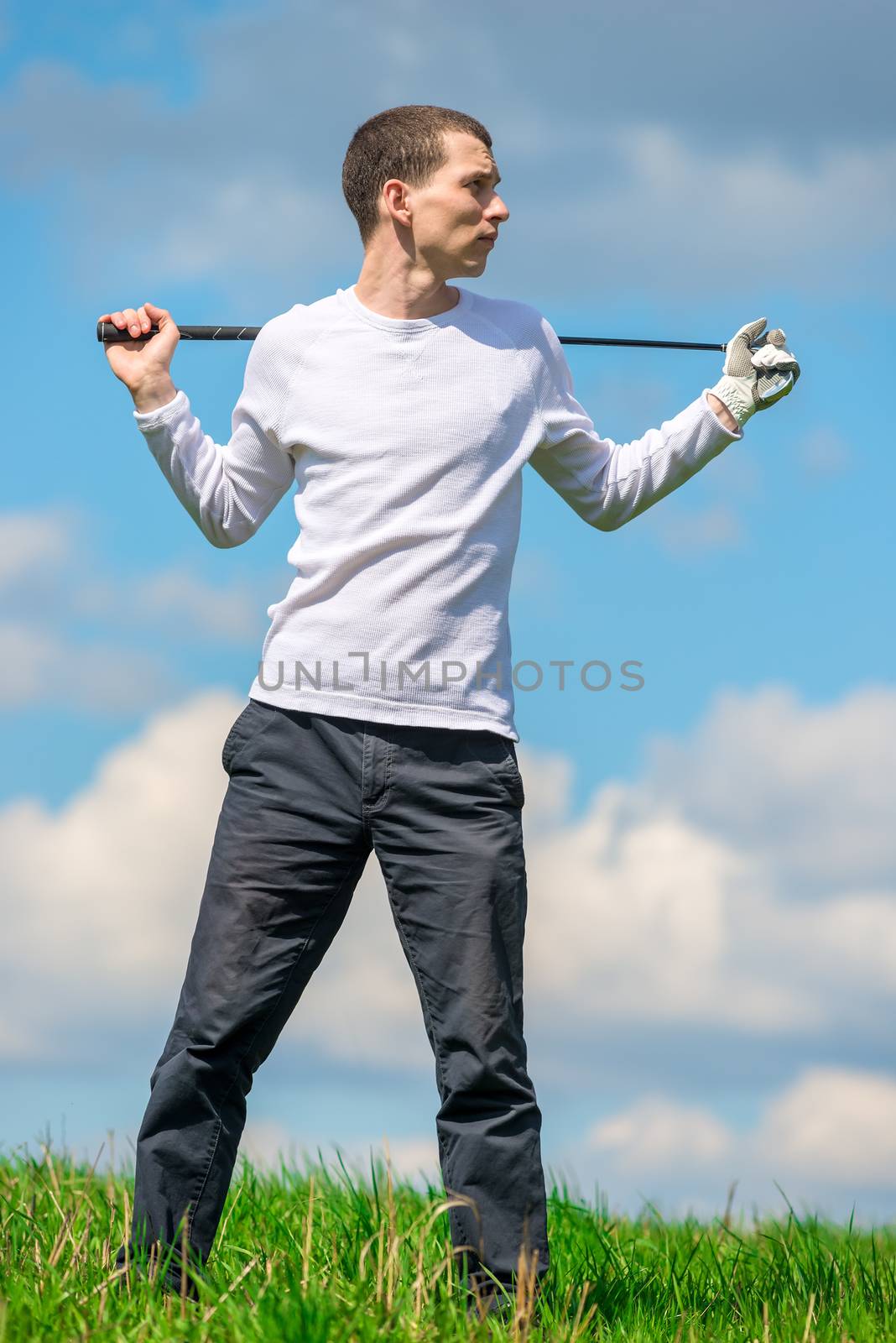 full-length portrait of a successful golfer in a golf club field