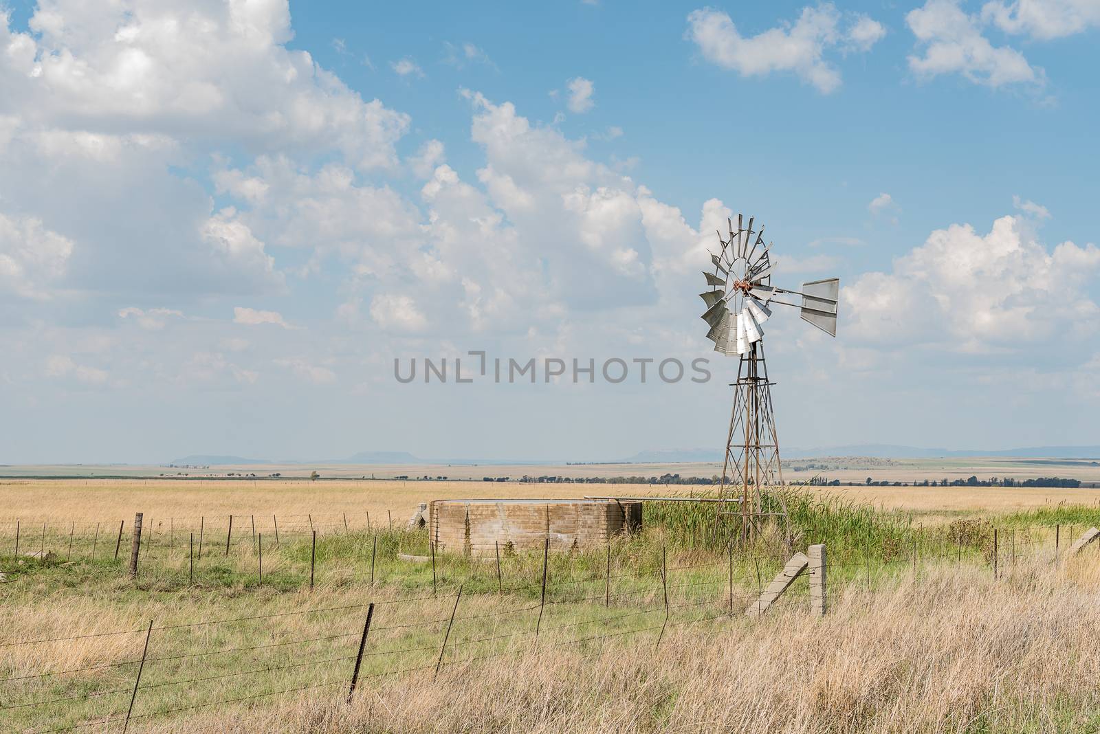 A farm scene with water-pumping windmill and dam next to the R703-road between Verkeerdevlei and Excelsior in the Free State Province of South Africa
