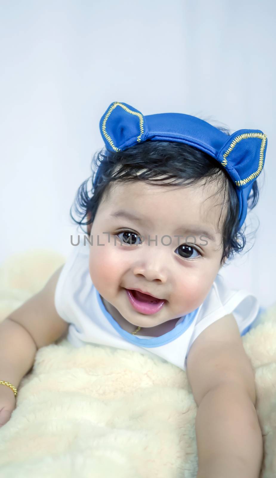 Asian Smiling baby girl crawling in bedroom