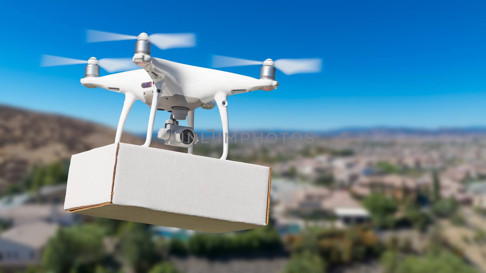 Unmanned Aircraft System (UAS) Quadcopter Drone Carrying Blank Package Over Neighborhood. by Feverpitched