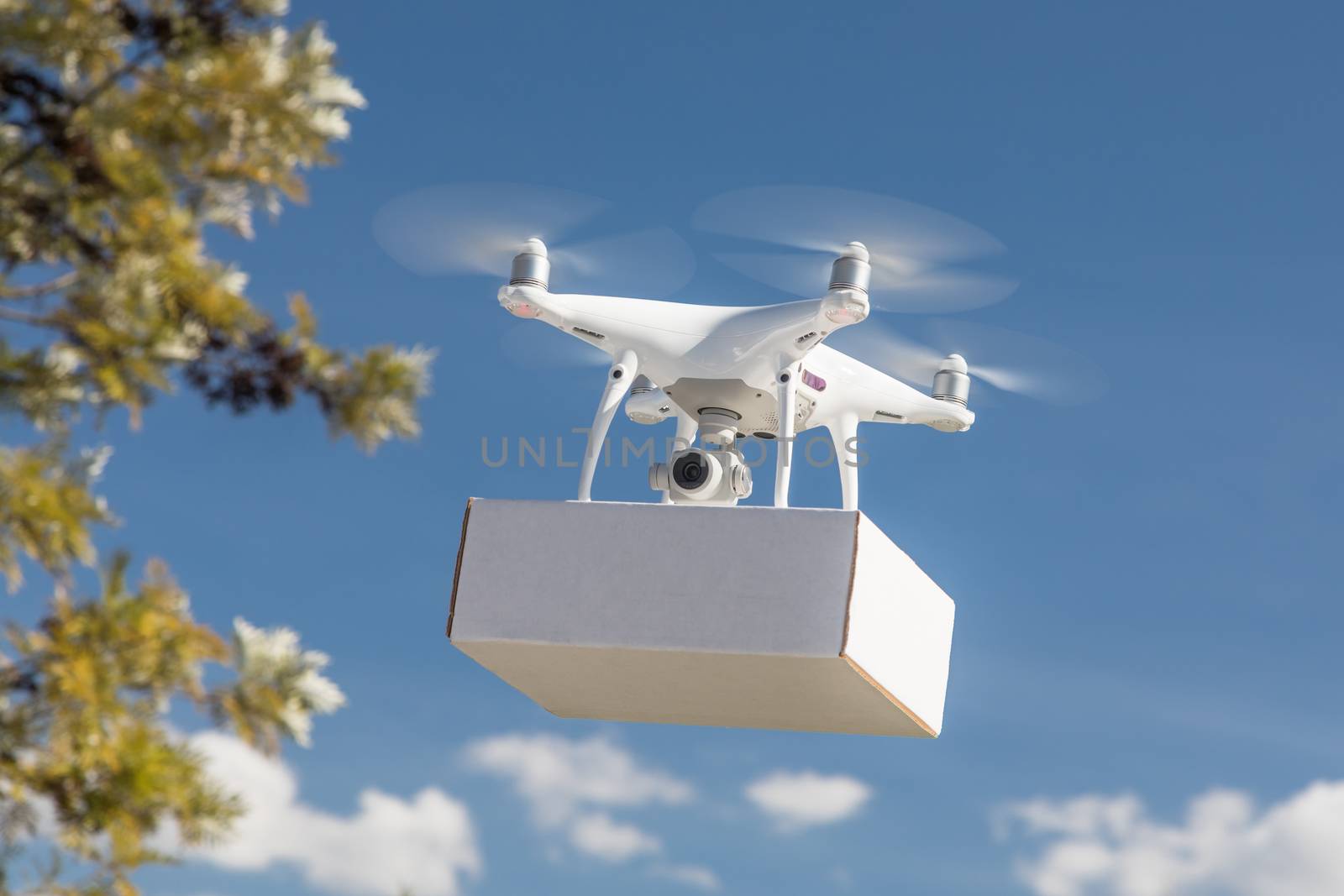 Unmanned Aircraft System (UAS) Quadcopter Drone Carrying Blank Package In The Air.