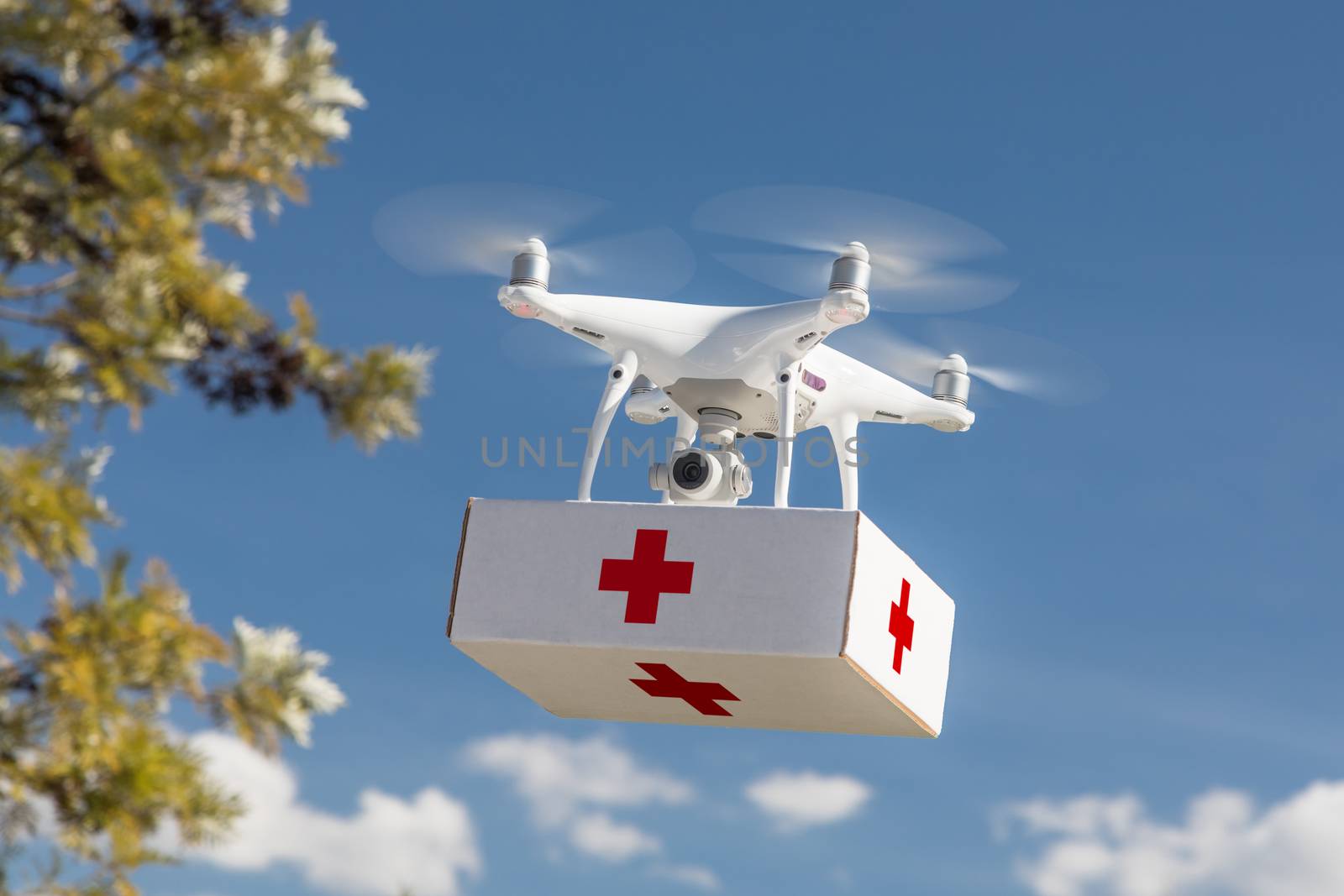 Unmanned Aircraft System (UAS) Quadcopter Drone Carrying First Aid Package In The Air.