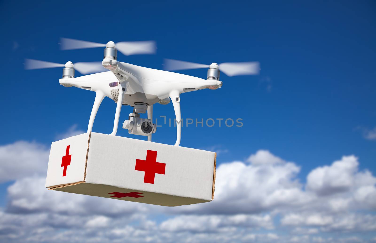 Unmanned Aircraft System (UAS) Quadcopter Drone Carrying First Aid Package In The Air.