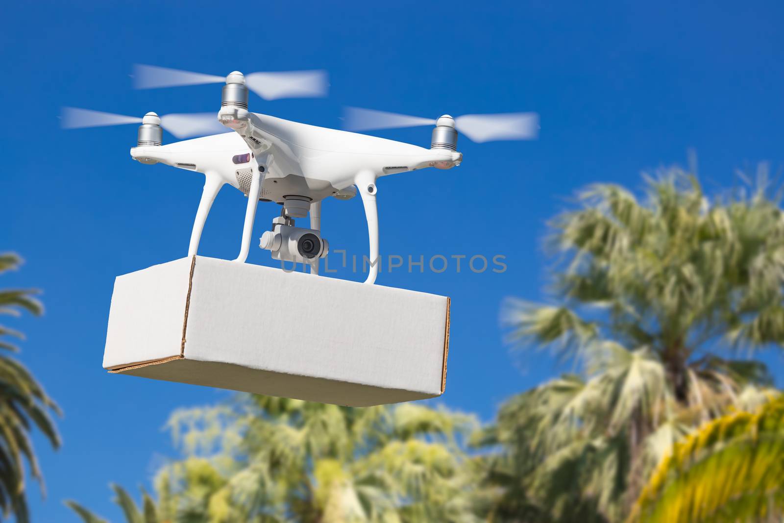 Unmanned Aircraft System (UAV) Quadcopter Drone Carrying Blank Package Over Tropical Terrain.