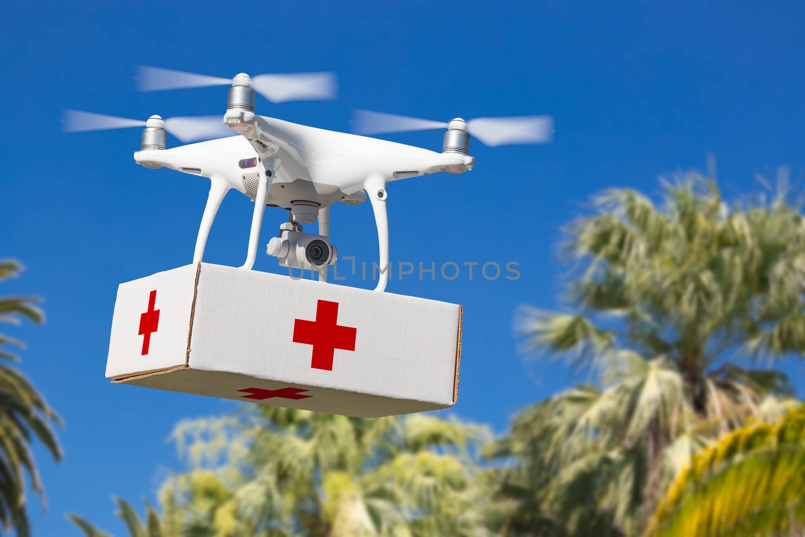 Unmanned Aircraft System (UAS) Quadcopter Drone Carrying First Aid Package Over Tropical Terrain.