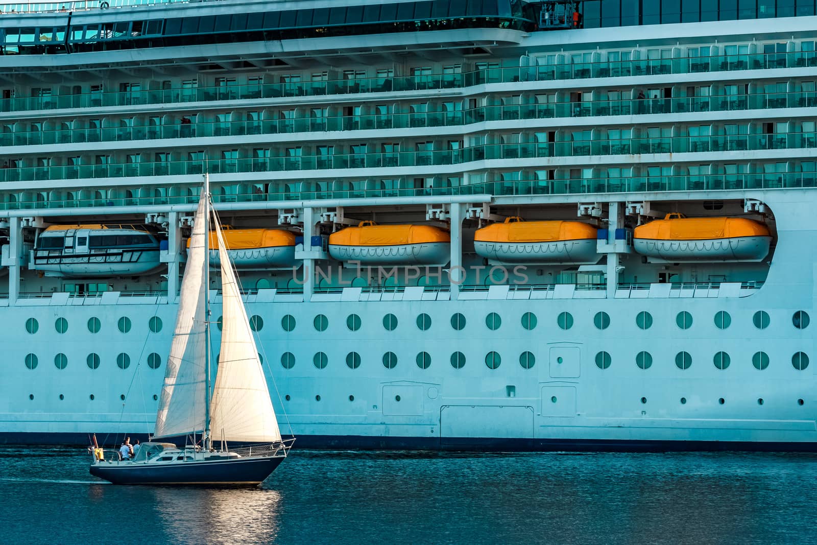 Blue sailboat against cruise liner by sengnsp