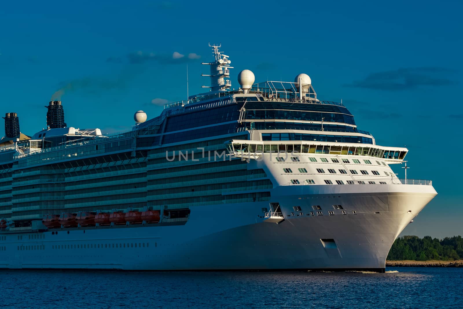 White giant brand new passenger ship moving in clear summer day