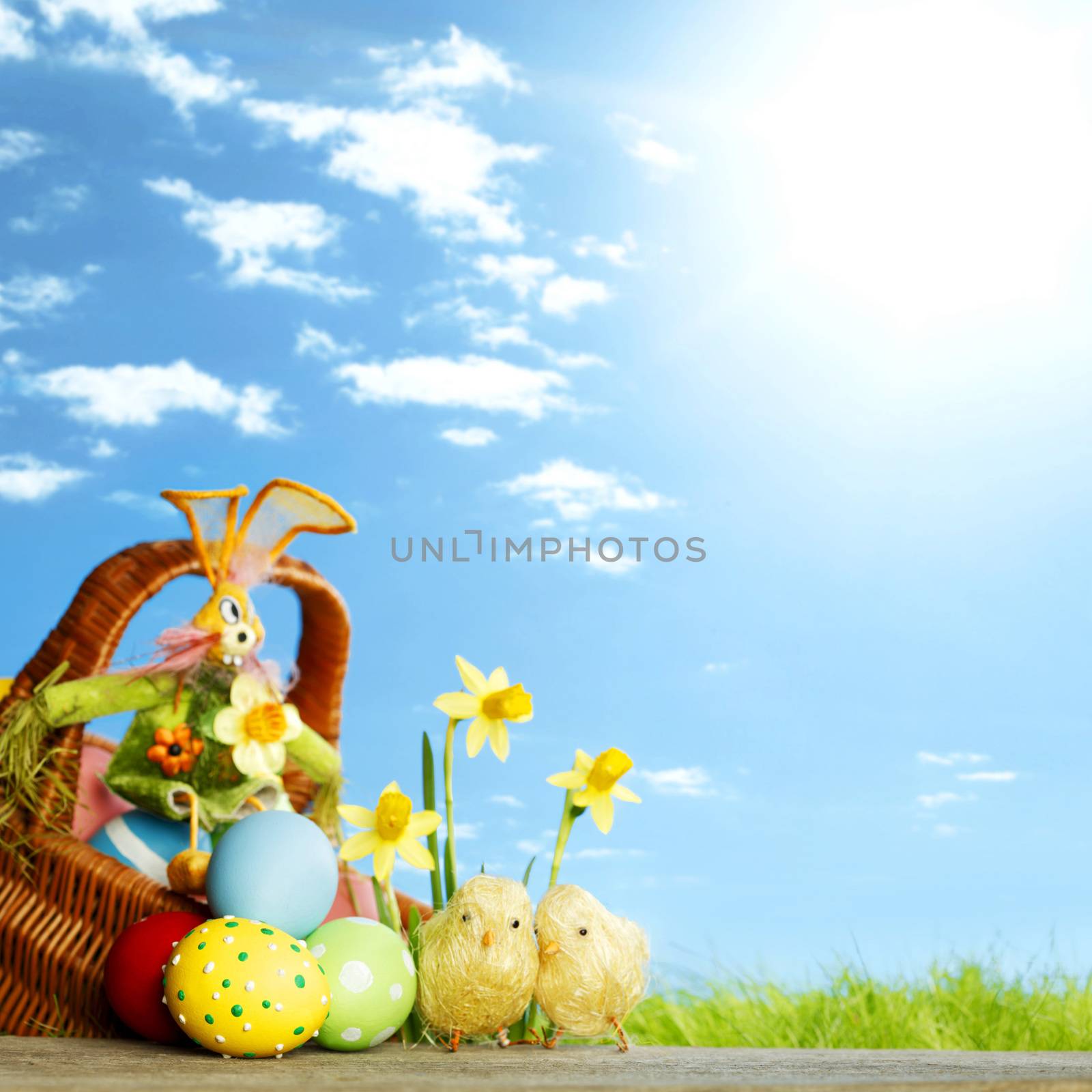 Easter basket with eggs on green meadow with flowers