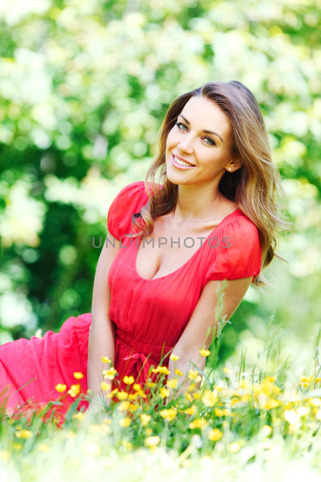 beautiful young woman in red dress sitting on grass