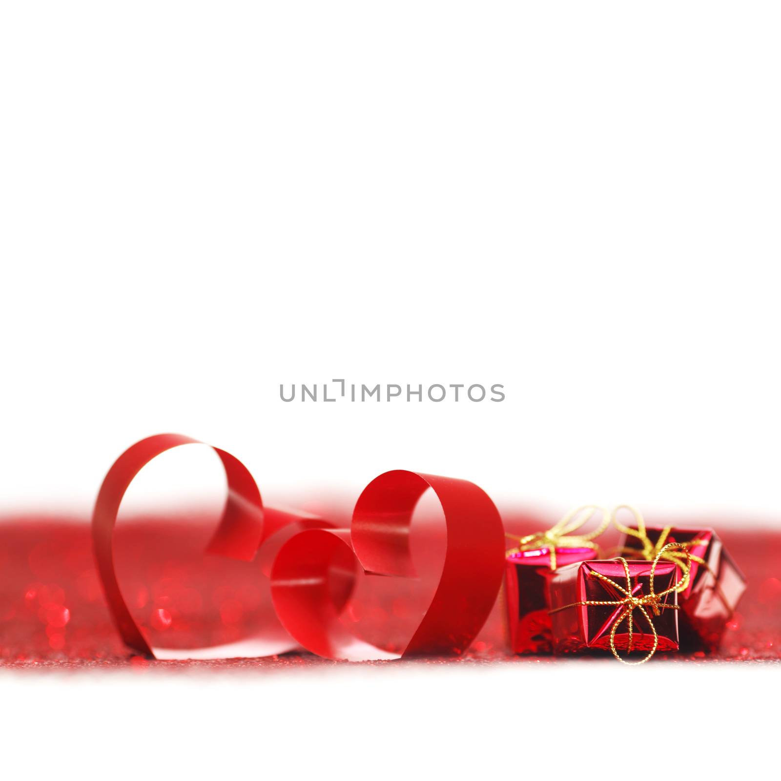 Valentines day ribbon hearts and gifts on decorative glitters, isolated on white