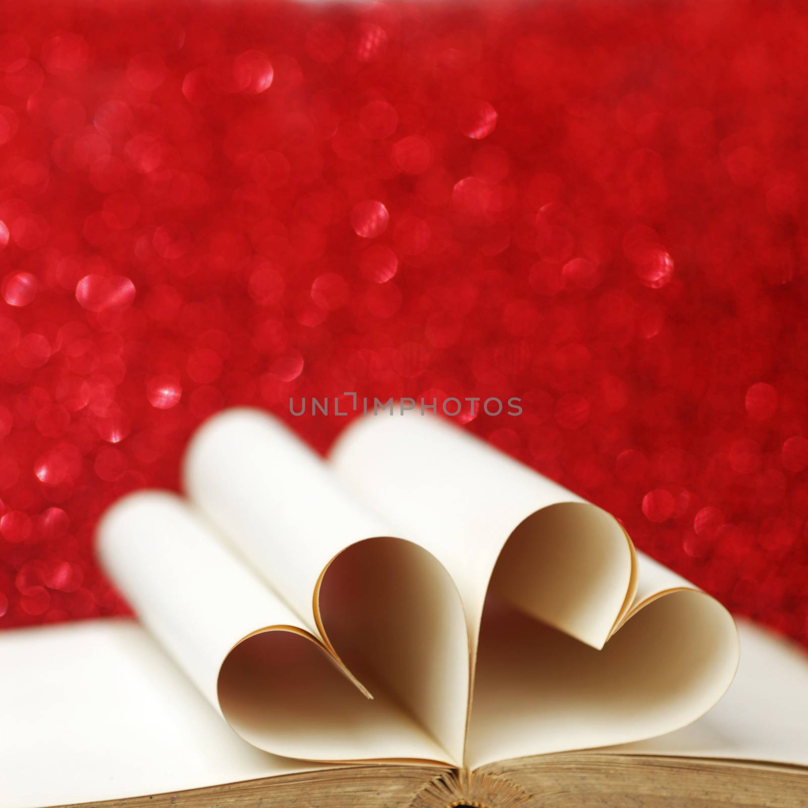 Heart shaped book pages on glitter background