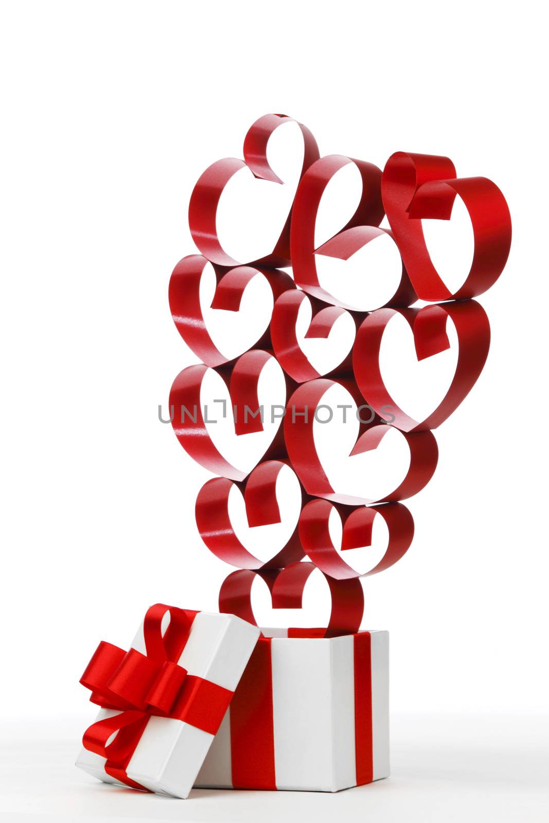 White box with red ribbons and decorative hearts isolated on white background