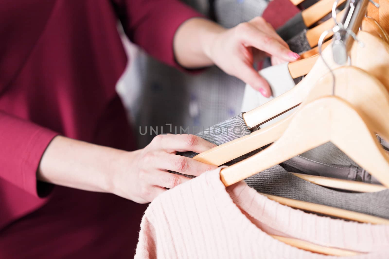 Closeup shot of hands of woman who choosing new clothes, fashion by Nobilior
