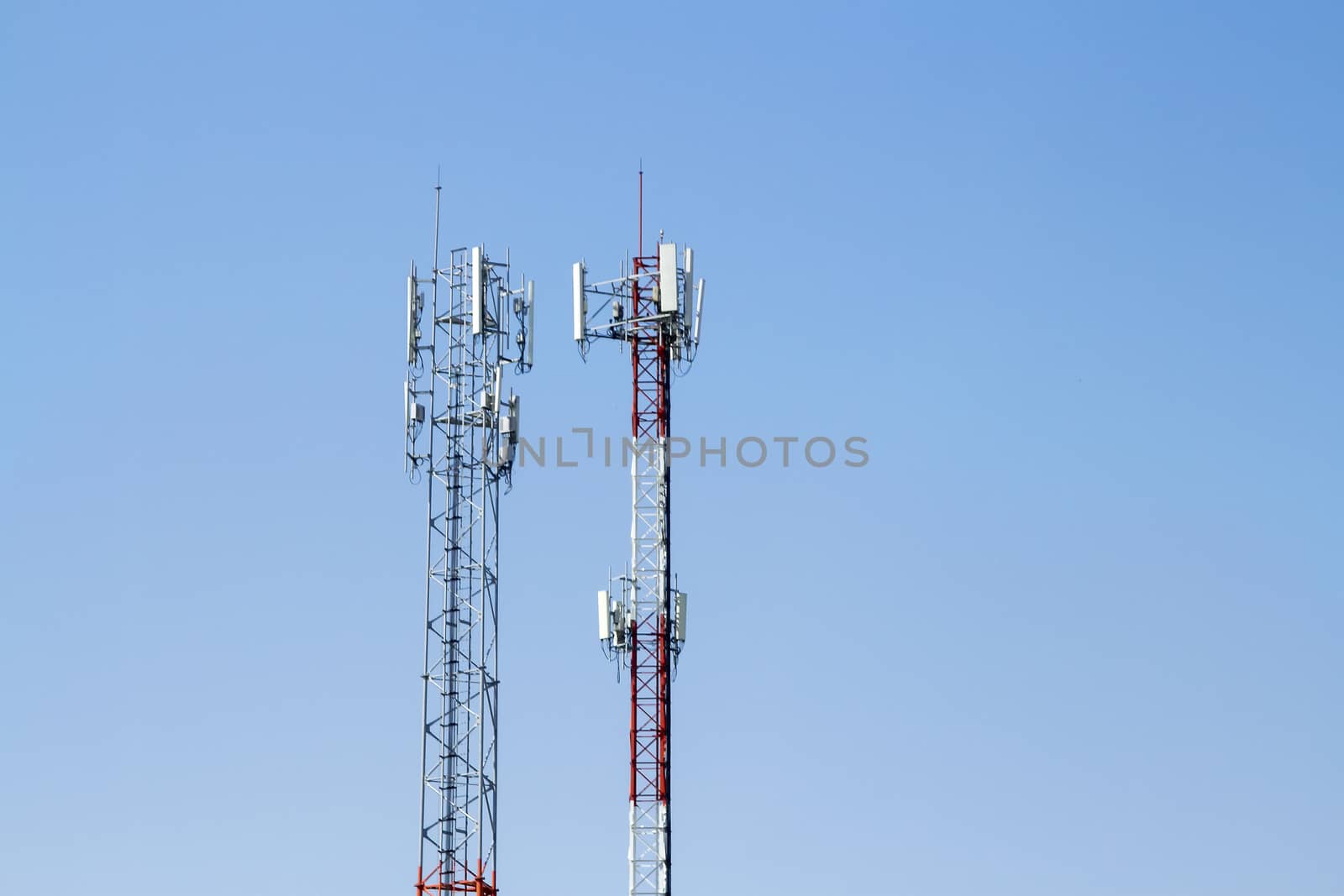 Mobile phone communication tower transmission  signal with blue sky background and antenna and twin