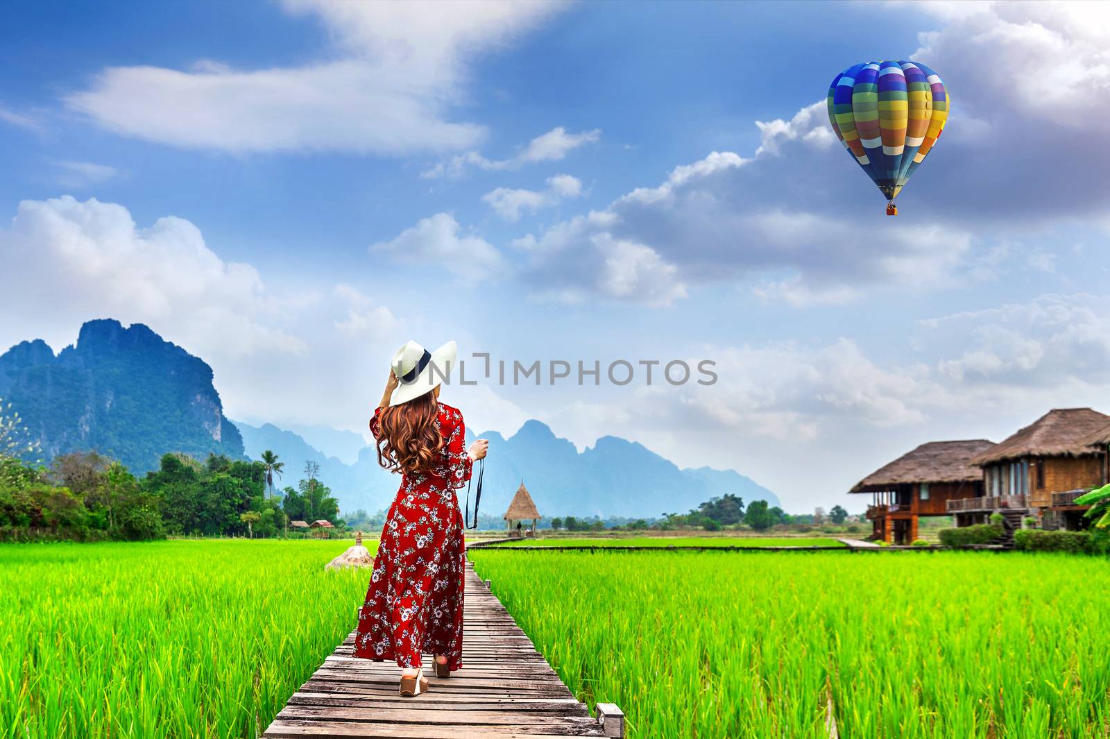 Young woman look at balloon and walking on wooden path with gree by gutarphotoghaphy