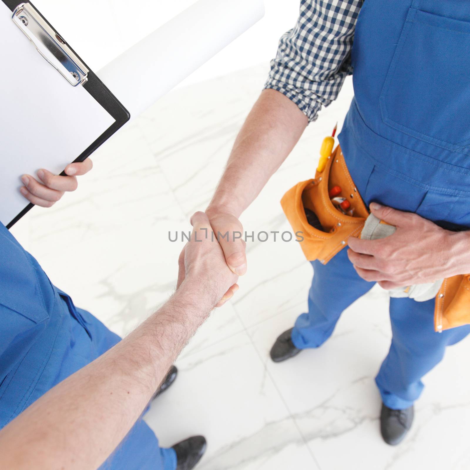 Two construction workers shaking hands, deal is finished concept