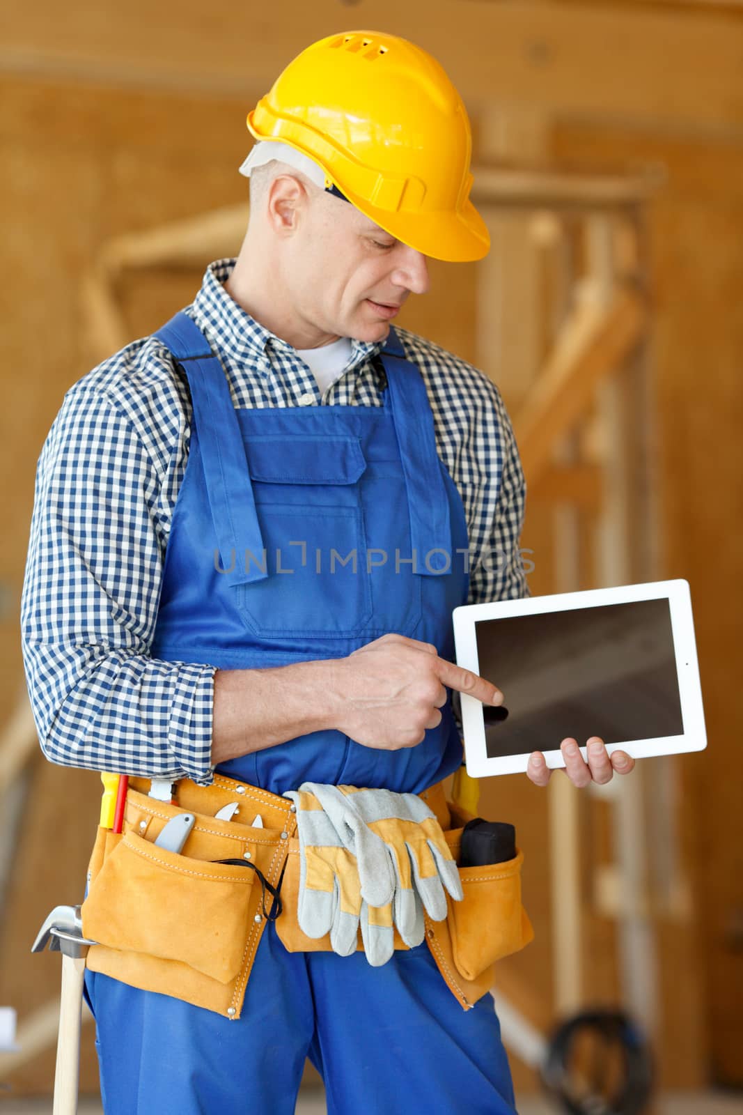 Construction worker pointing at digital tablet at construction site