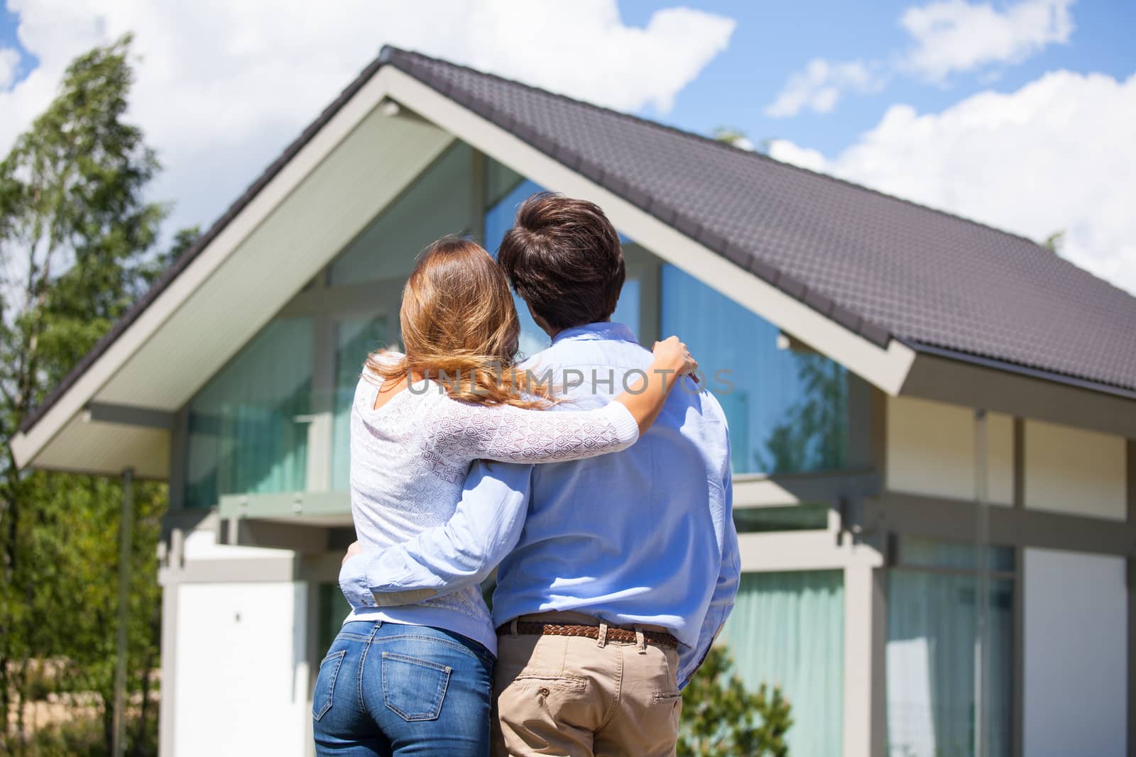 Happy couple walking looking at their house