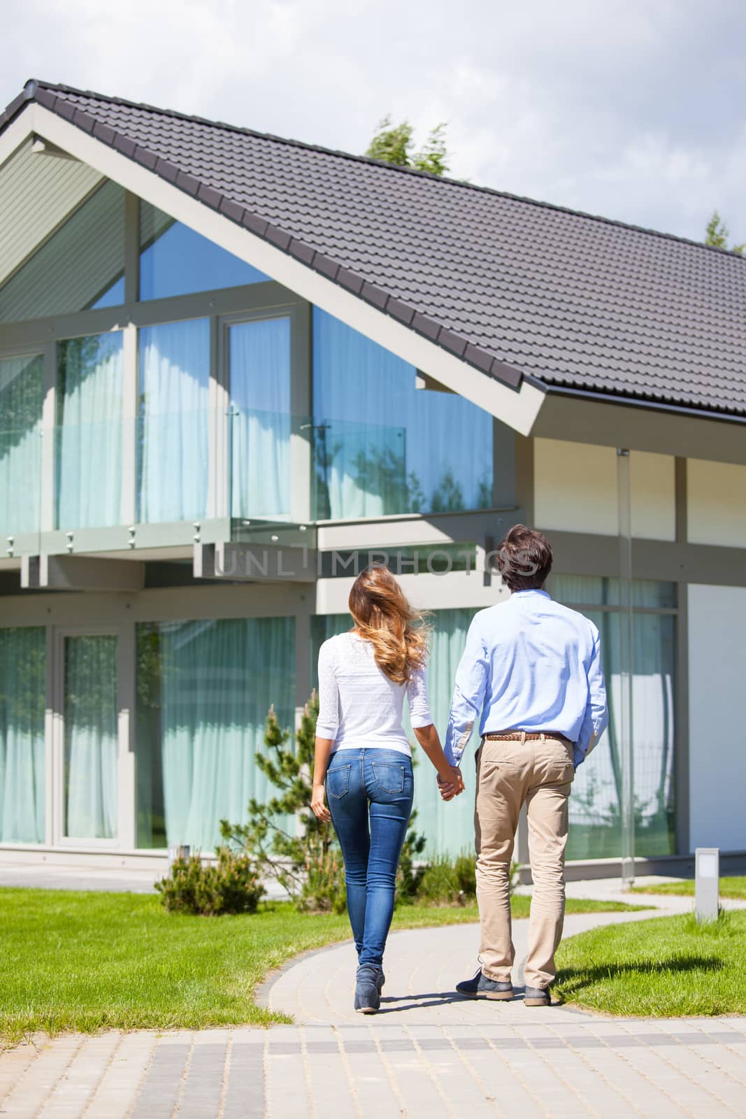 Happy couple walking outdoors near their house