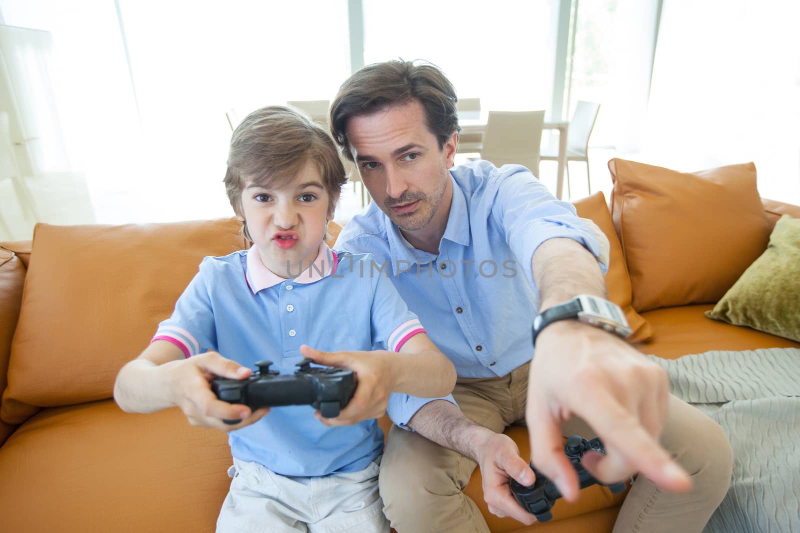 Father and son playing videogame at home by ALotOfPeople