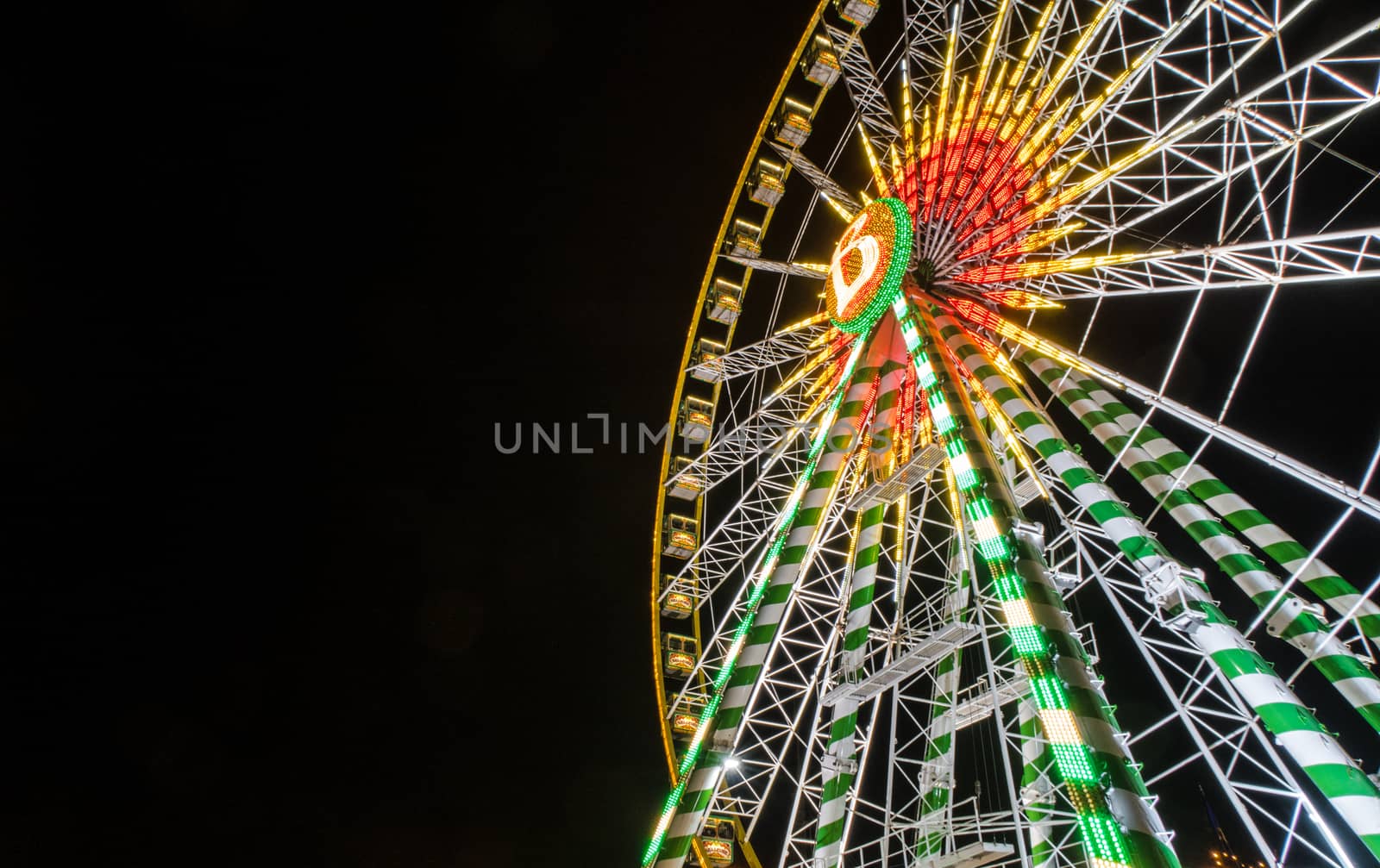 Ferris wheel on pitch black night background in germany at low angle of view