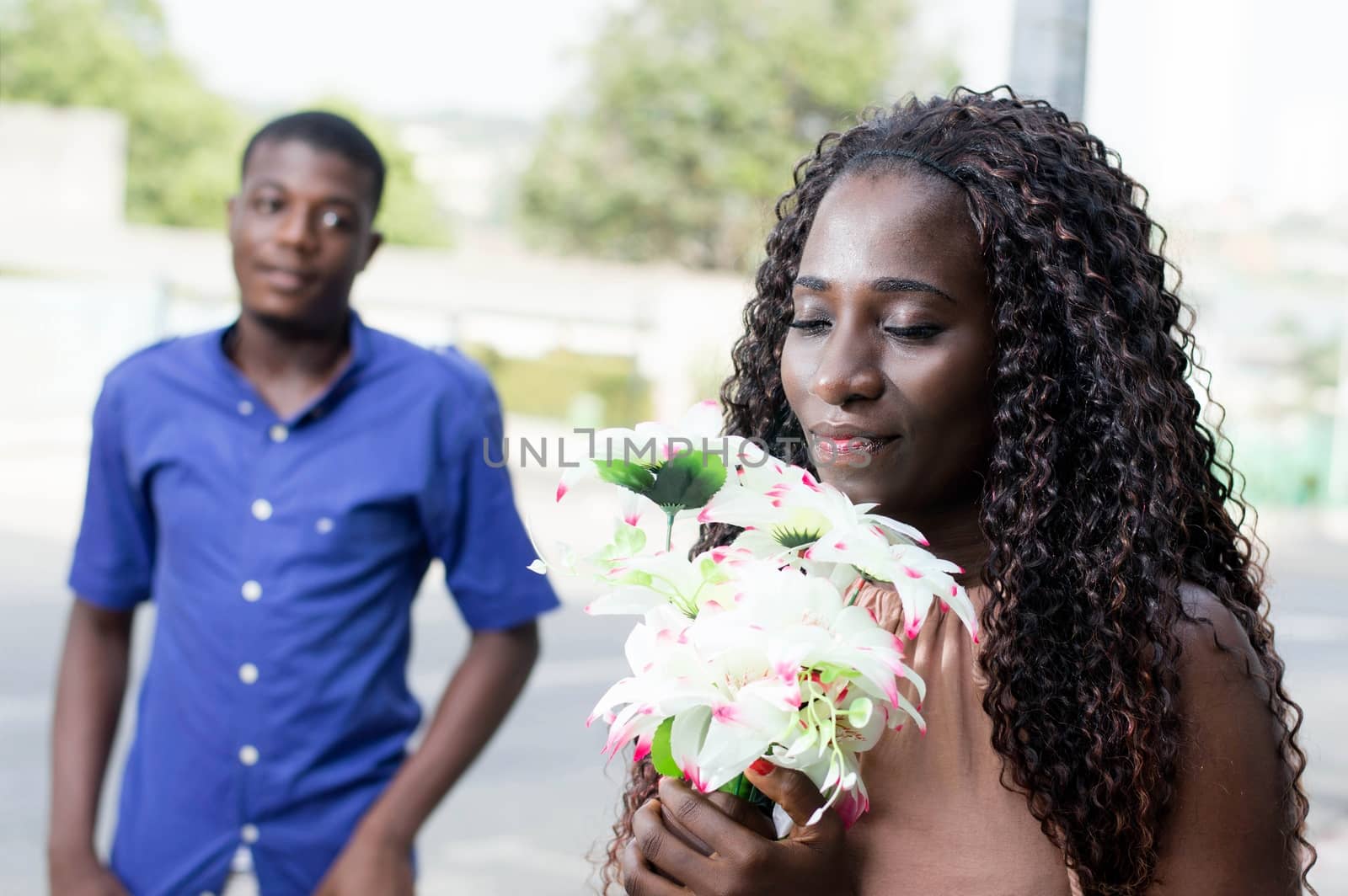 young woman with closed eyes, accepts her flower bouquet with pleasure and love.
