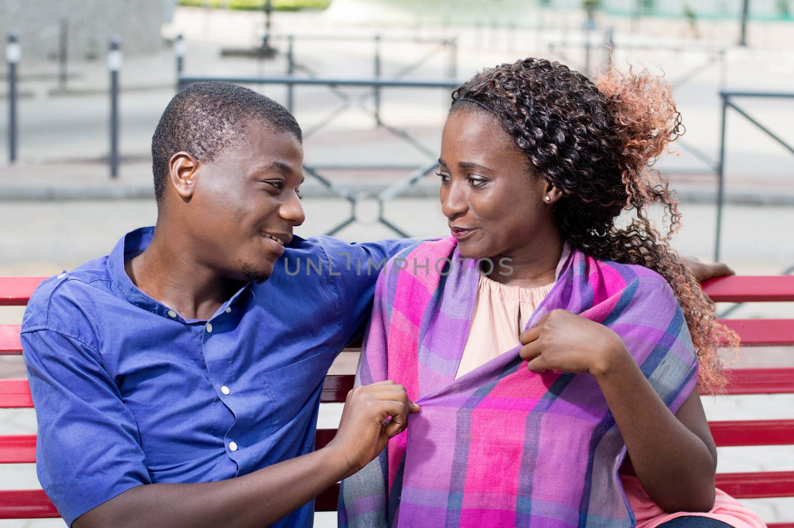 These young people sitting face to face, look  into their eyes with a smile.