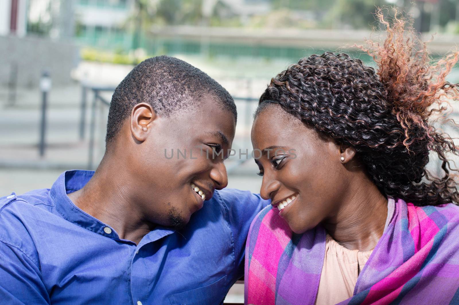 These young people sitting face to face, look  into their eyes with a smile.