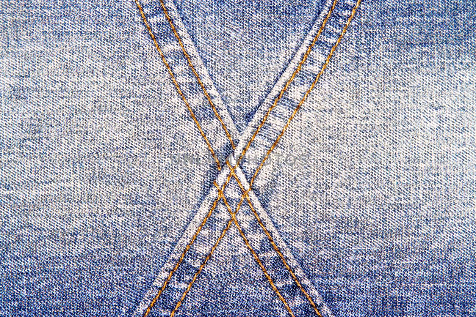 Blue jeans texture background and  cross orange seam 