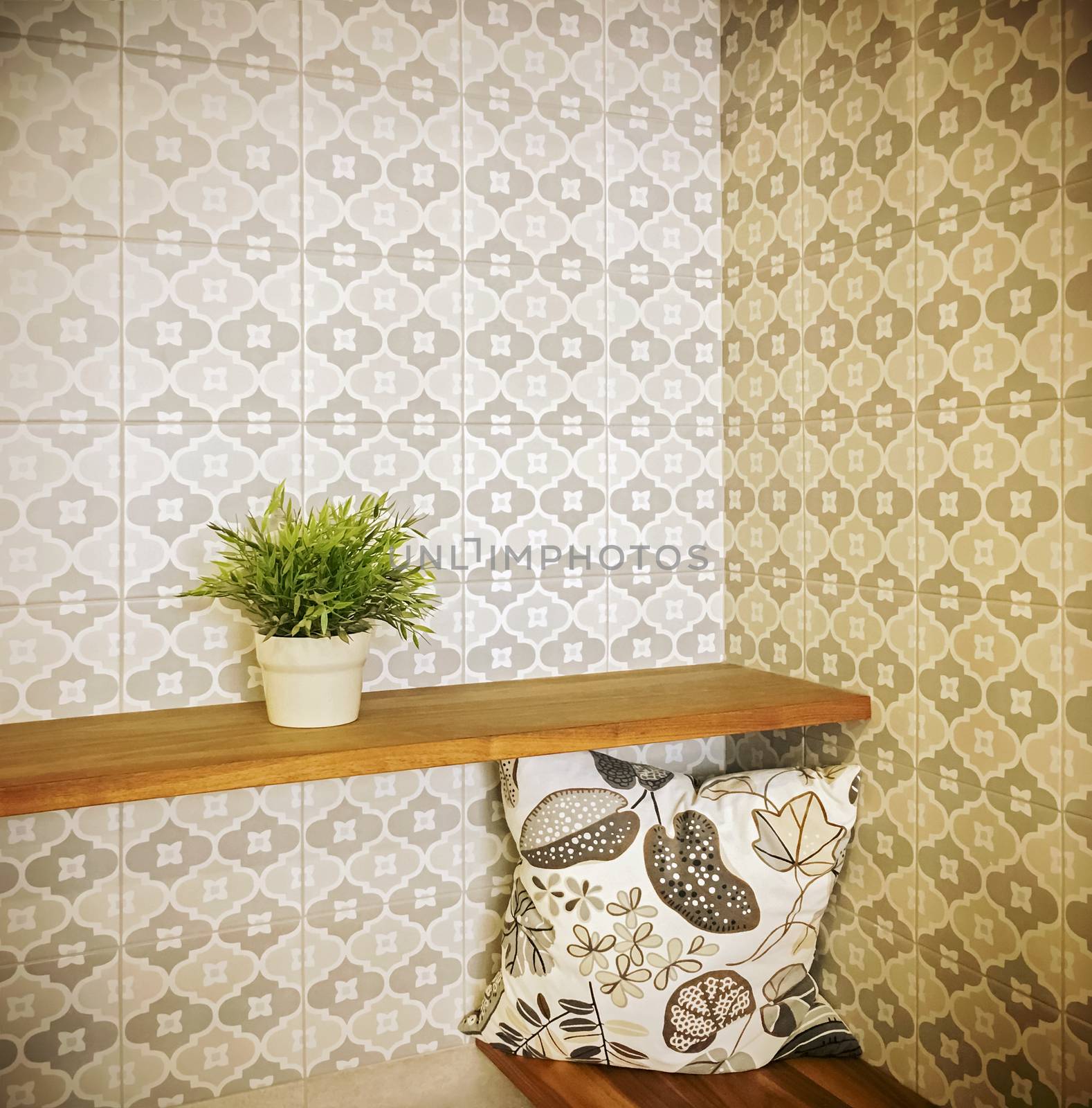 Detail of an entrance hall with green plant on a shelf and retro style wallpaper.