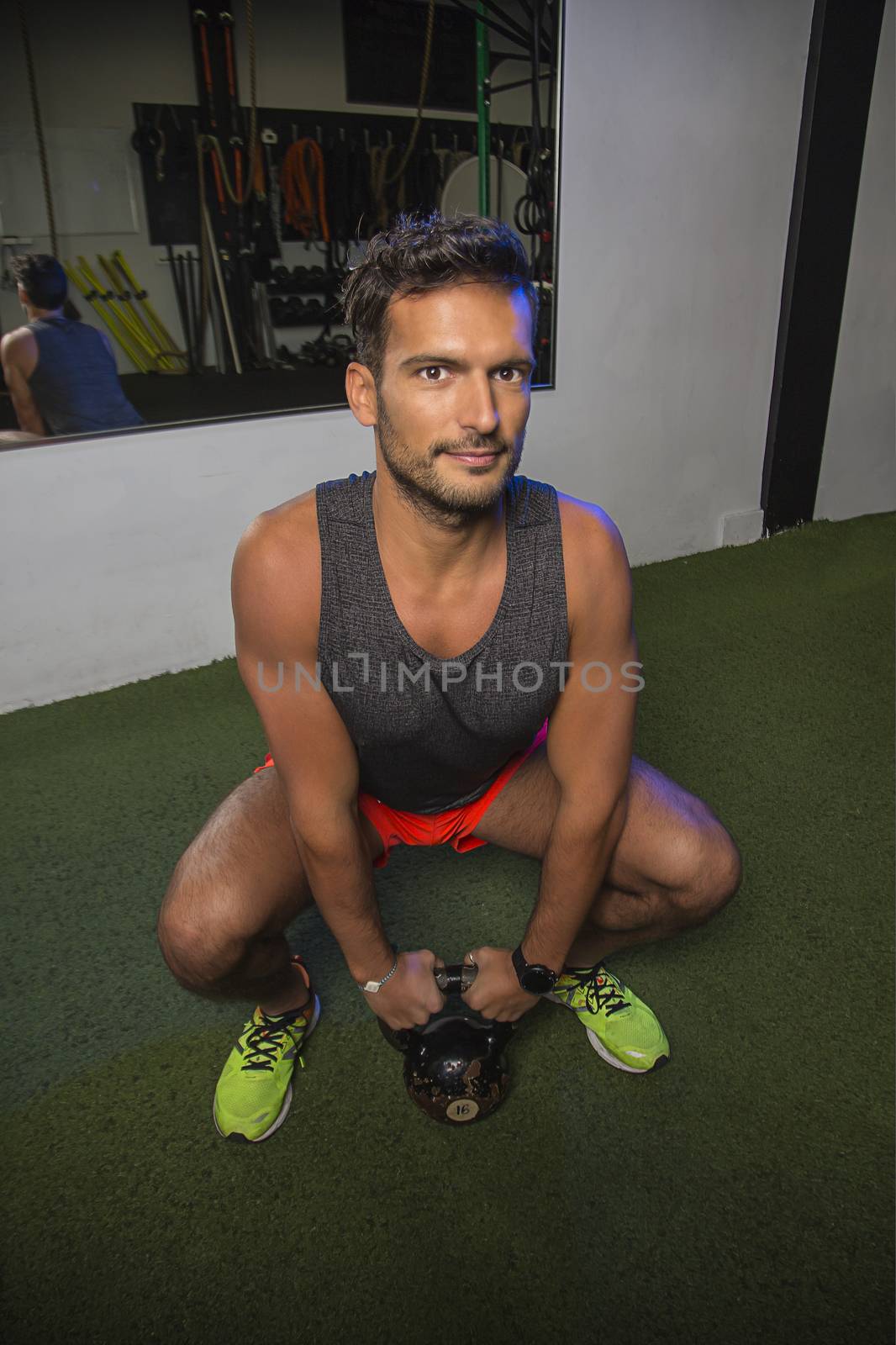 Squatting with a kettlebell by mypstudio