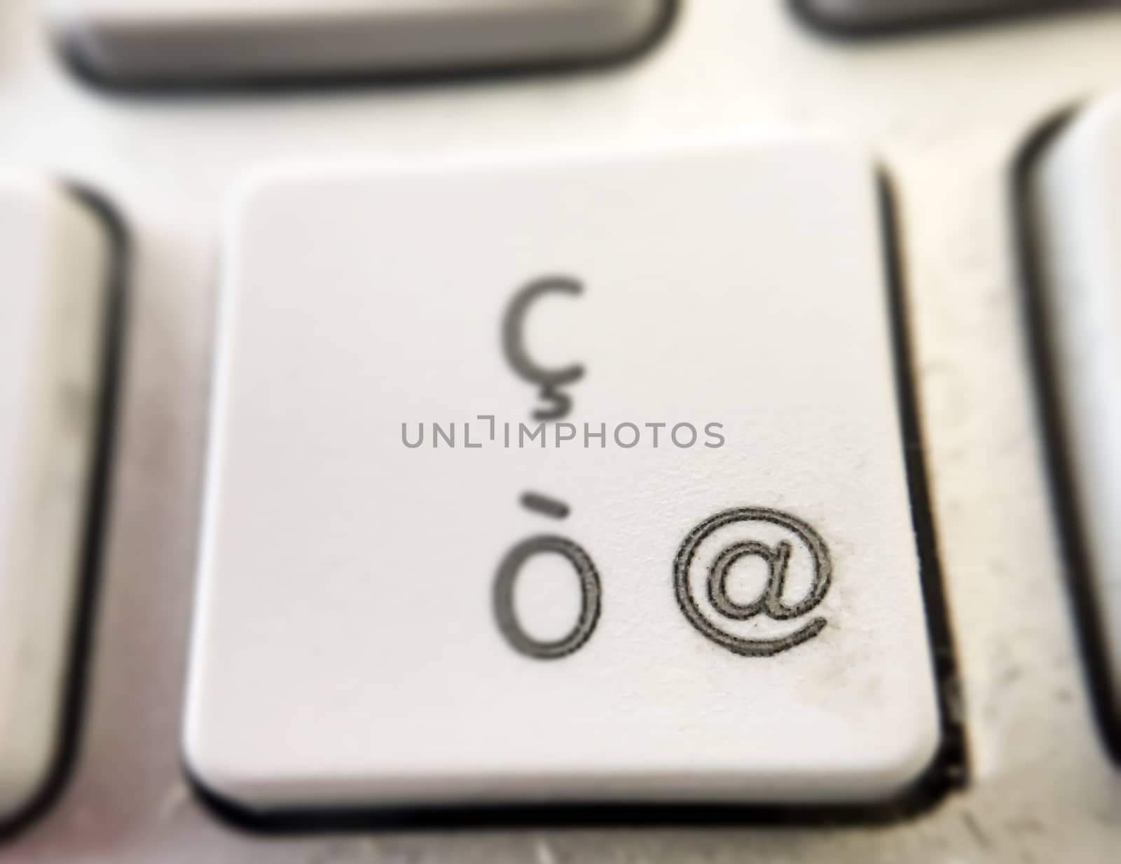 close-up view of of the button of a computer keyboard with the letter "ò" and the "@" symbol