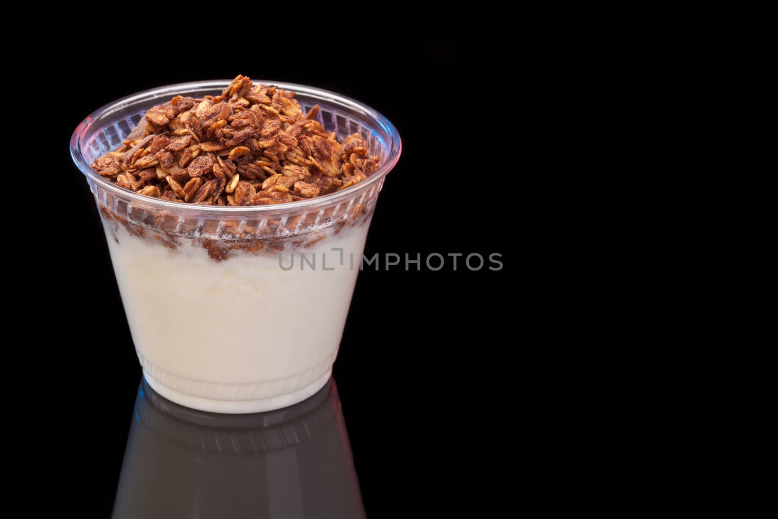 Yogurt with chocolade granola on black background with copyspace