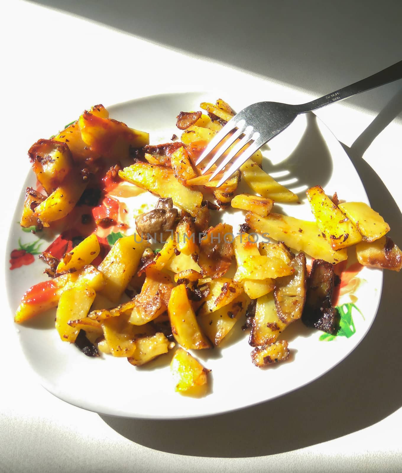 Fried potatoes with mushrooms on a plate