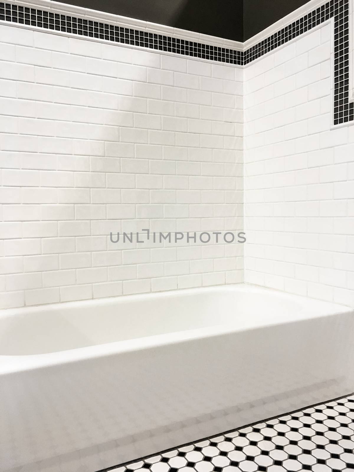 Clean and new modern bathroom with white ceramic tile walls.