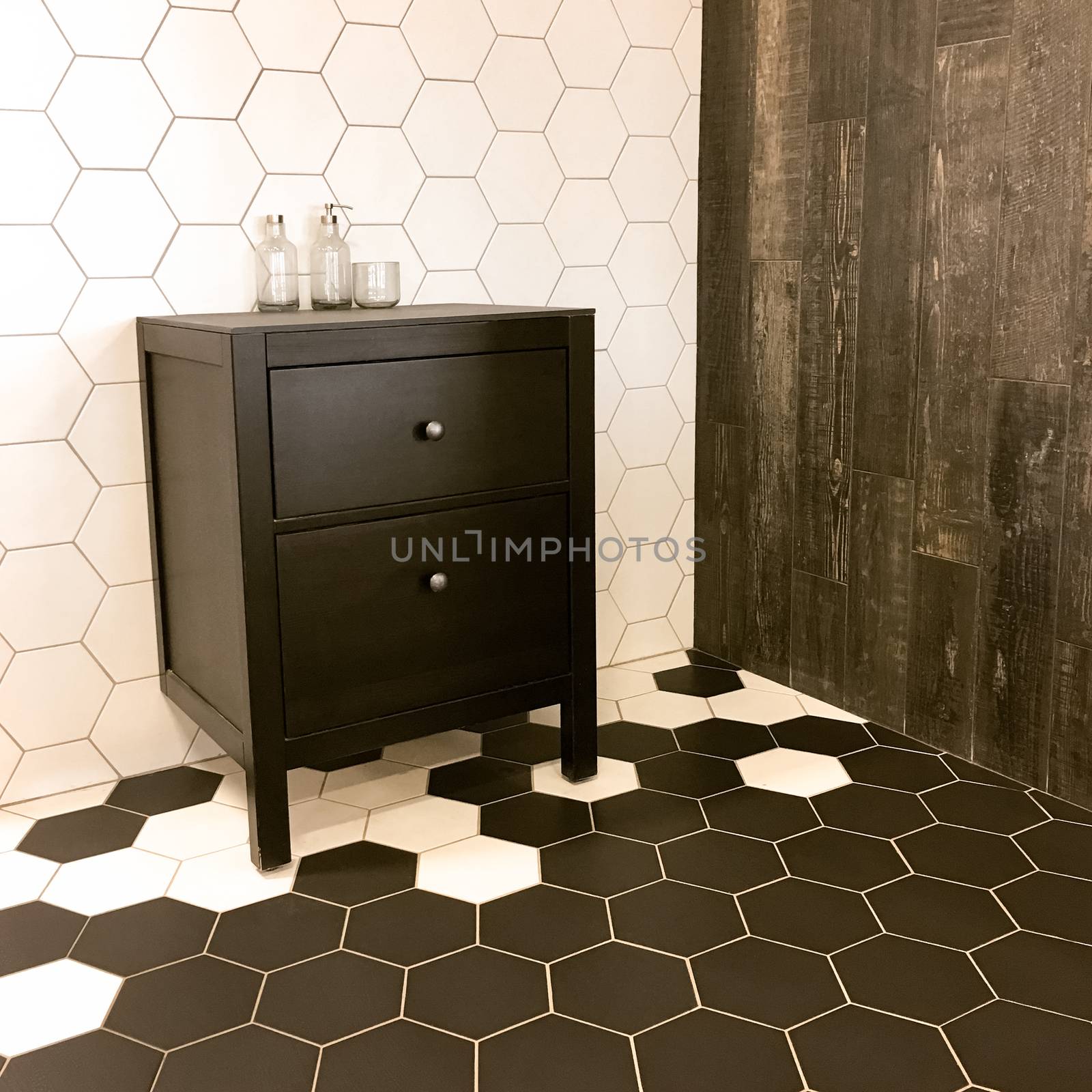 Spacious bathroom with tiled floor and black drawer unit by anikasalsera