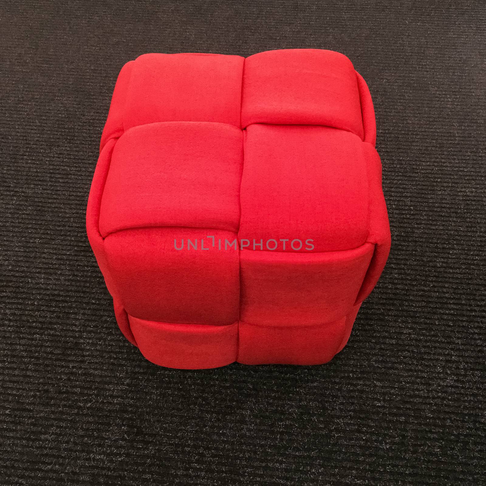 Modern red cube chair on gray carpet floor by anikasalsera