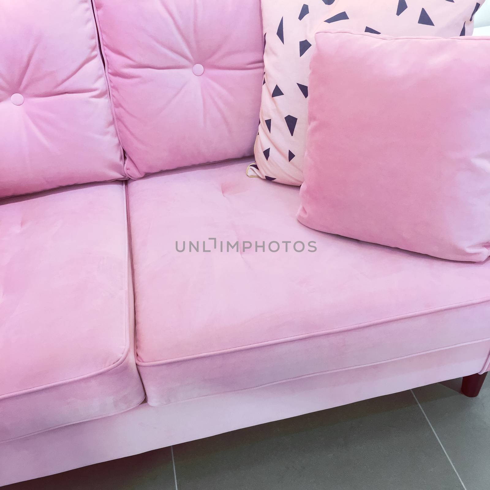 Fancy pink velvet sofa with soft cushions. Expensive furniture.