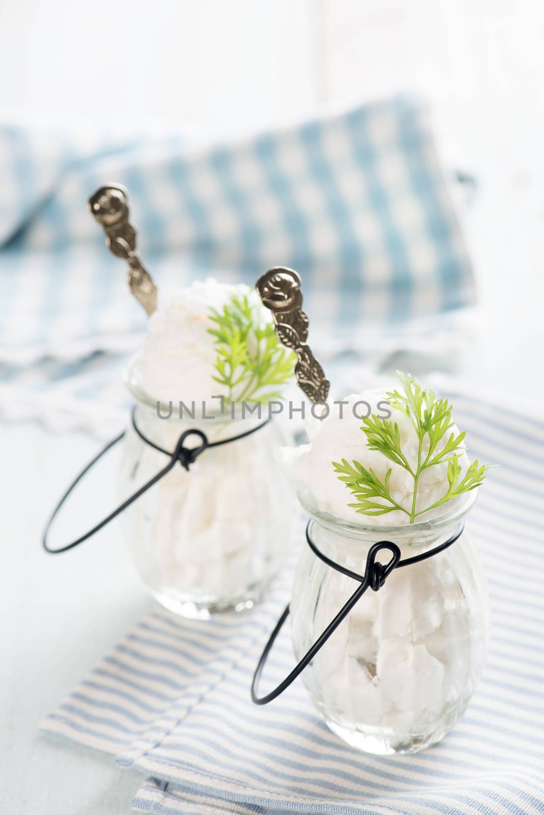Yoghurt ice cream in cup on white rustic wooden background.