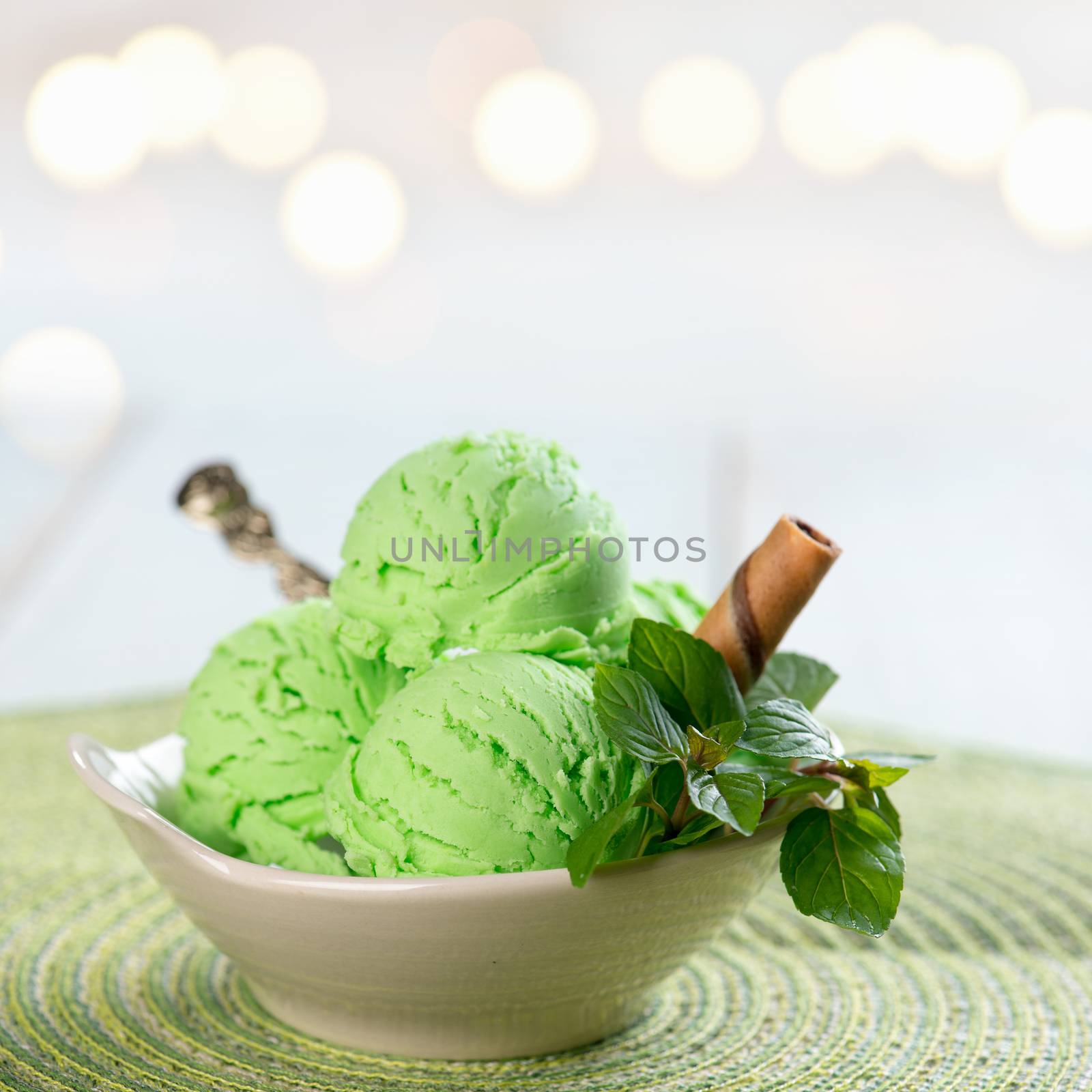 Bowl of mint ice cream on wooden background.