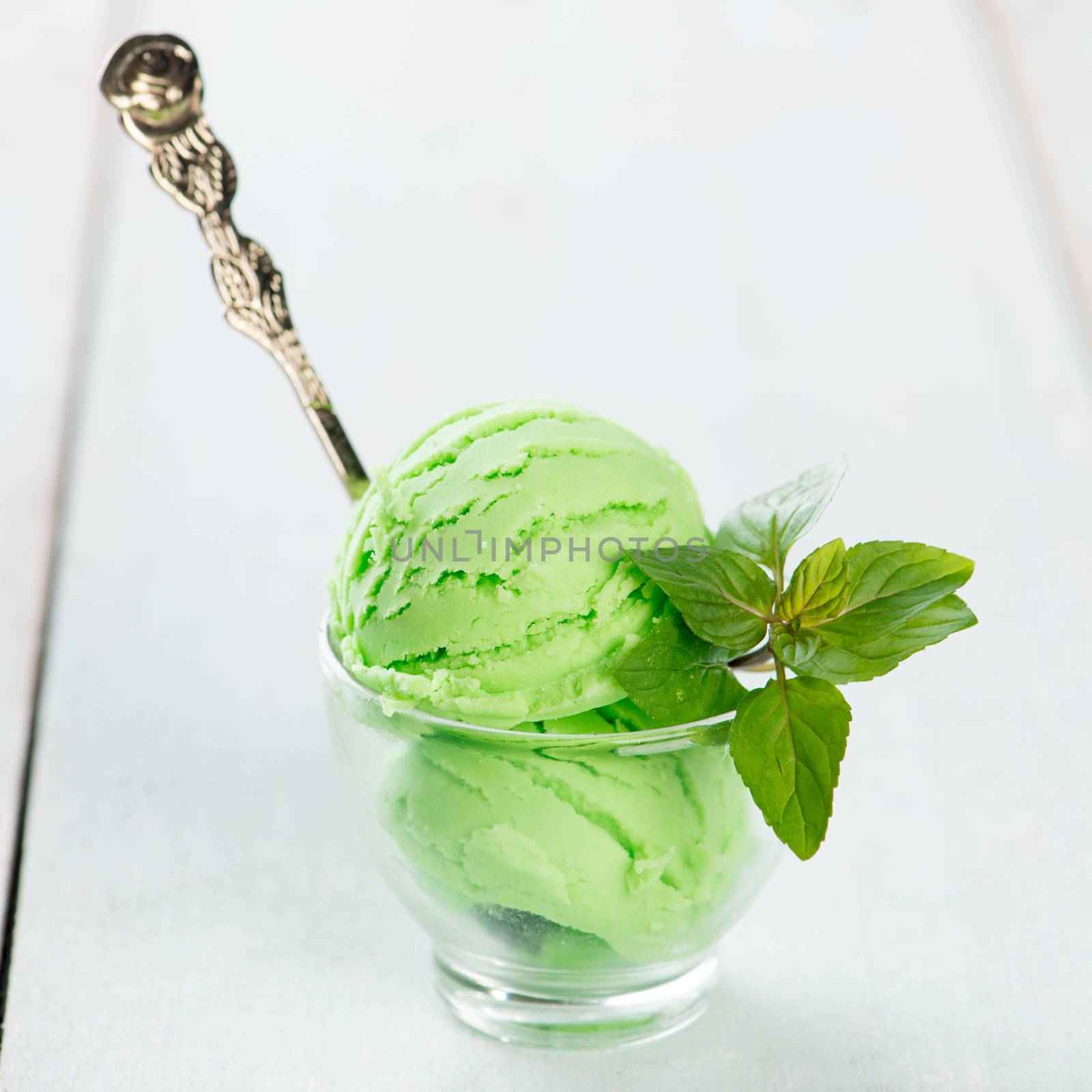 Cup of honeydew ice cream on wooden background.