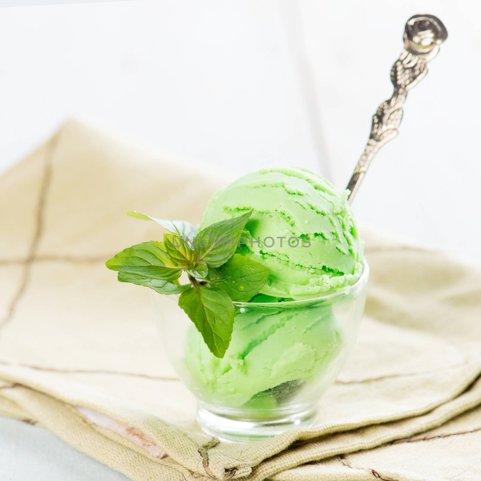 Cup of mint ice cream on wooden background.