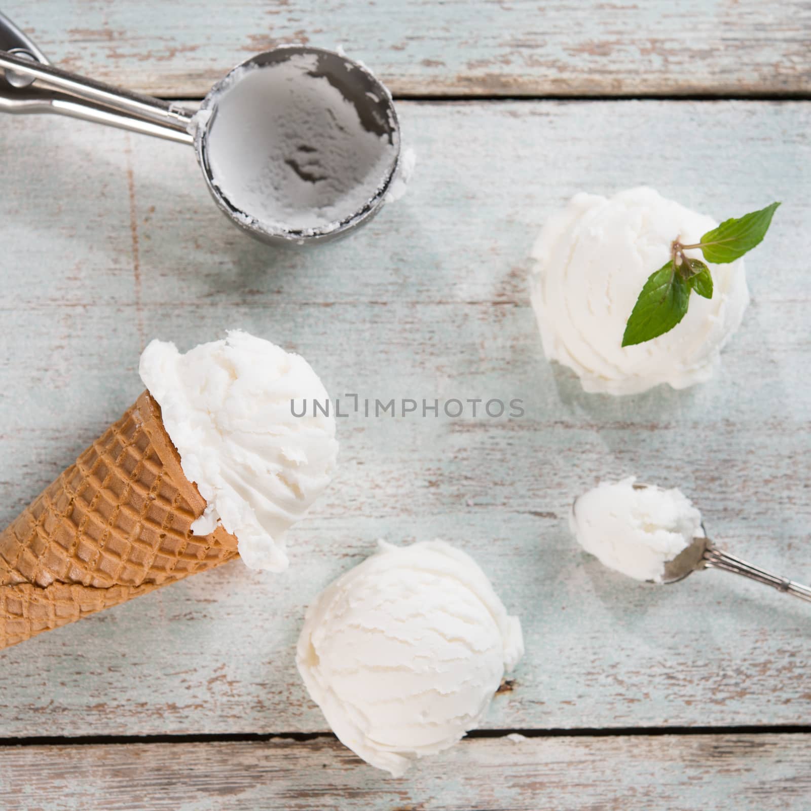 Top view white ice cream wafer cone on bright rustic wooden background. 