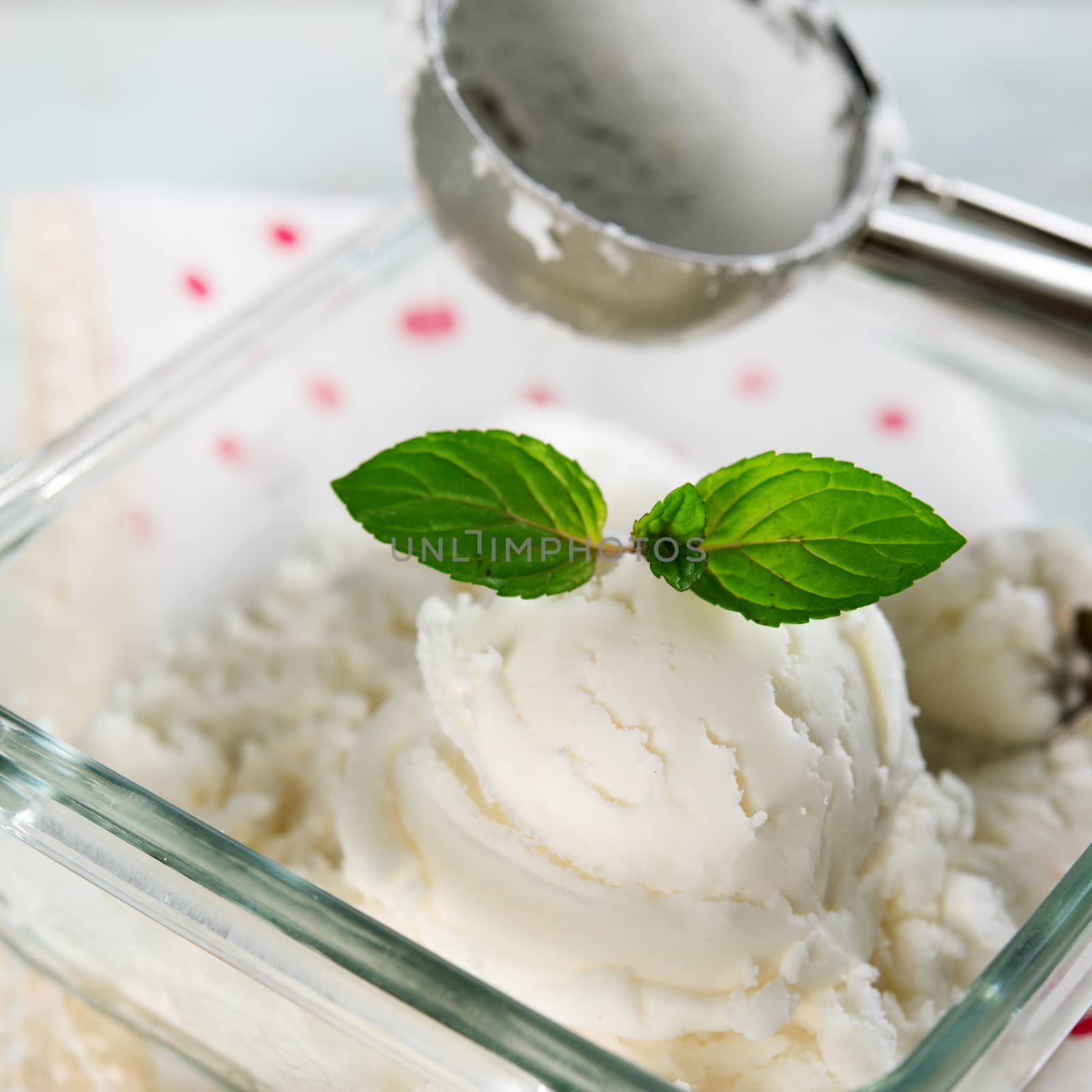 Milk ice cream in bowl on white wooden background.