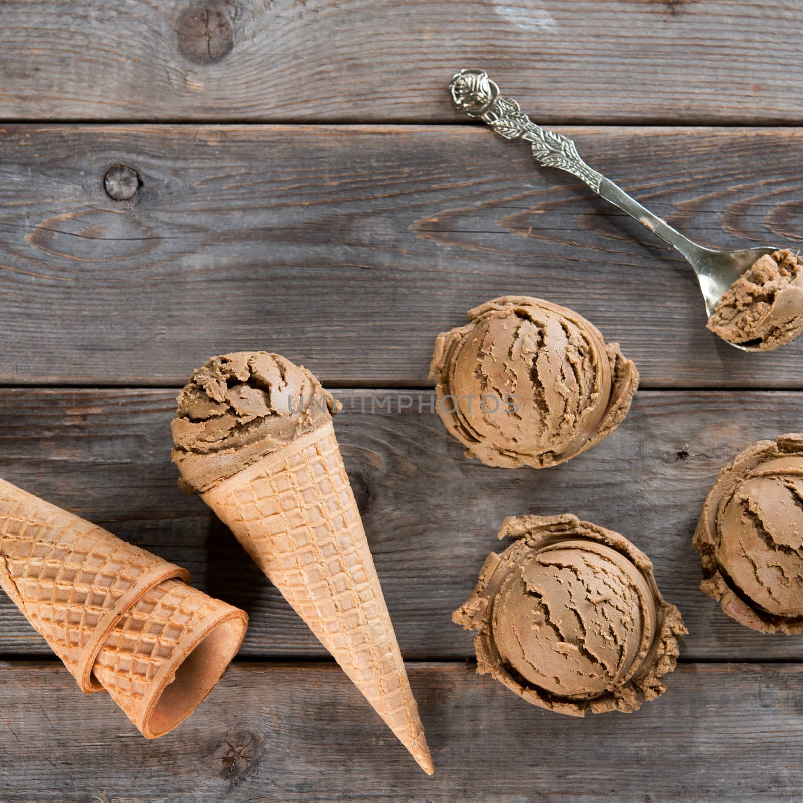 Top view chocolate ice cream in waffle cone on wooden background. Copy space on above.