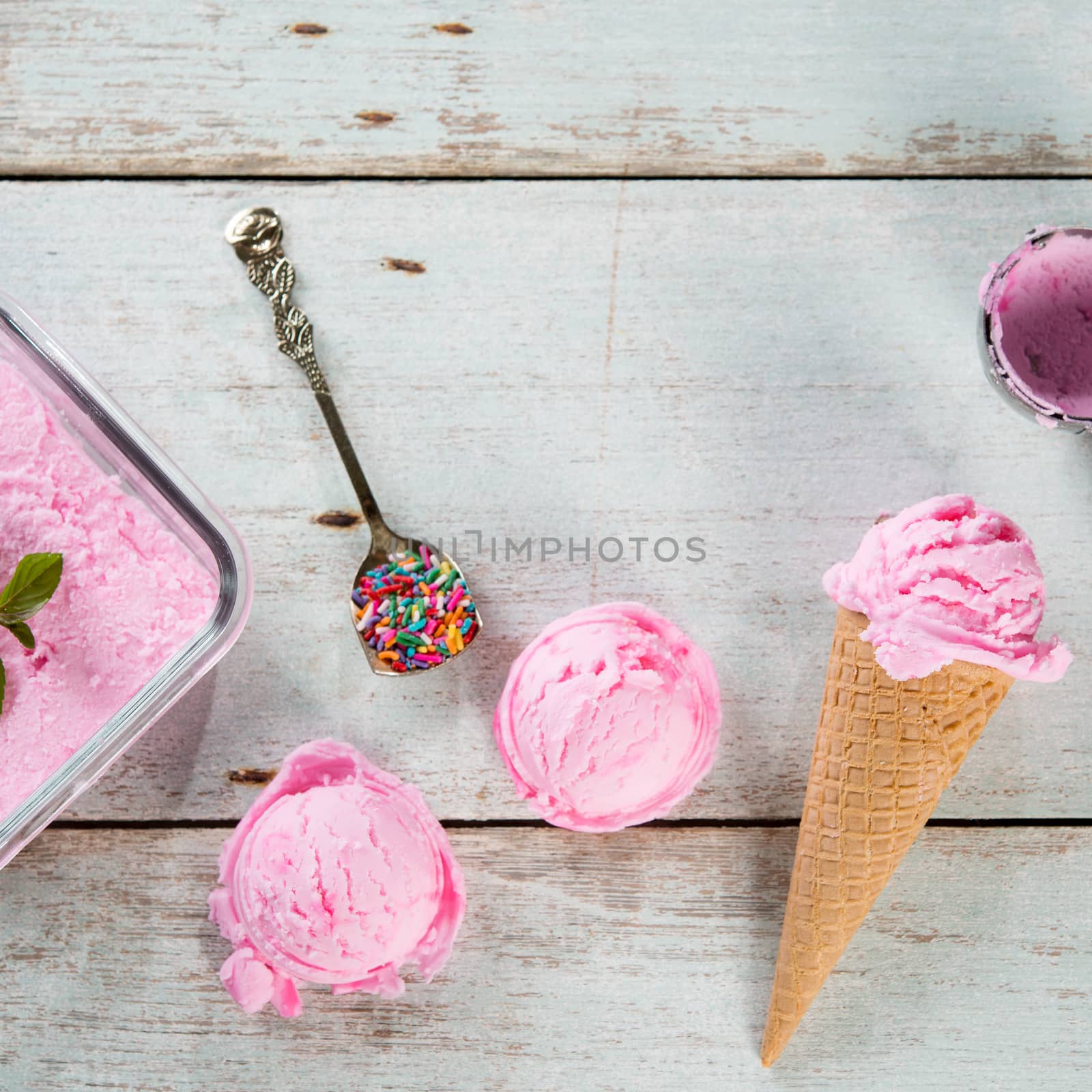 Top view strawberry ice cream waffle cone on wooden background.