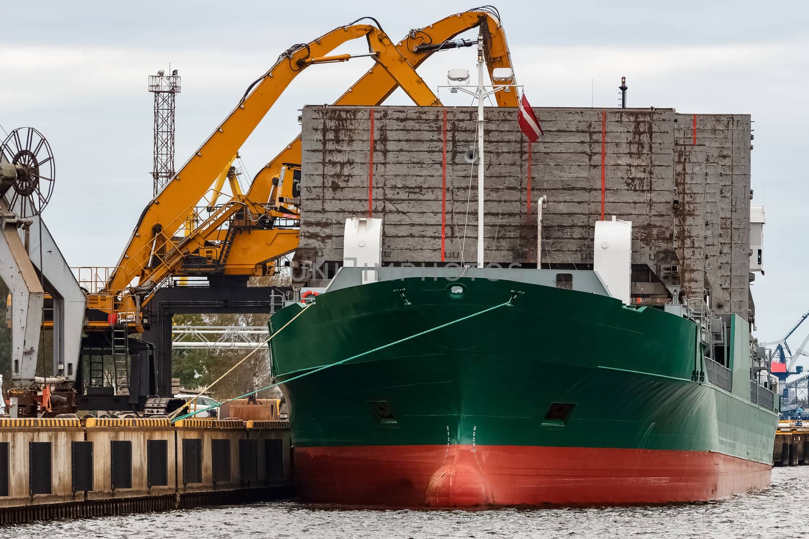 Green cargo ship loading in the port of Riga, Europe
