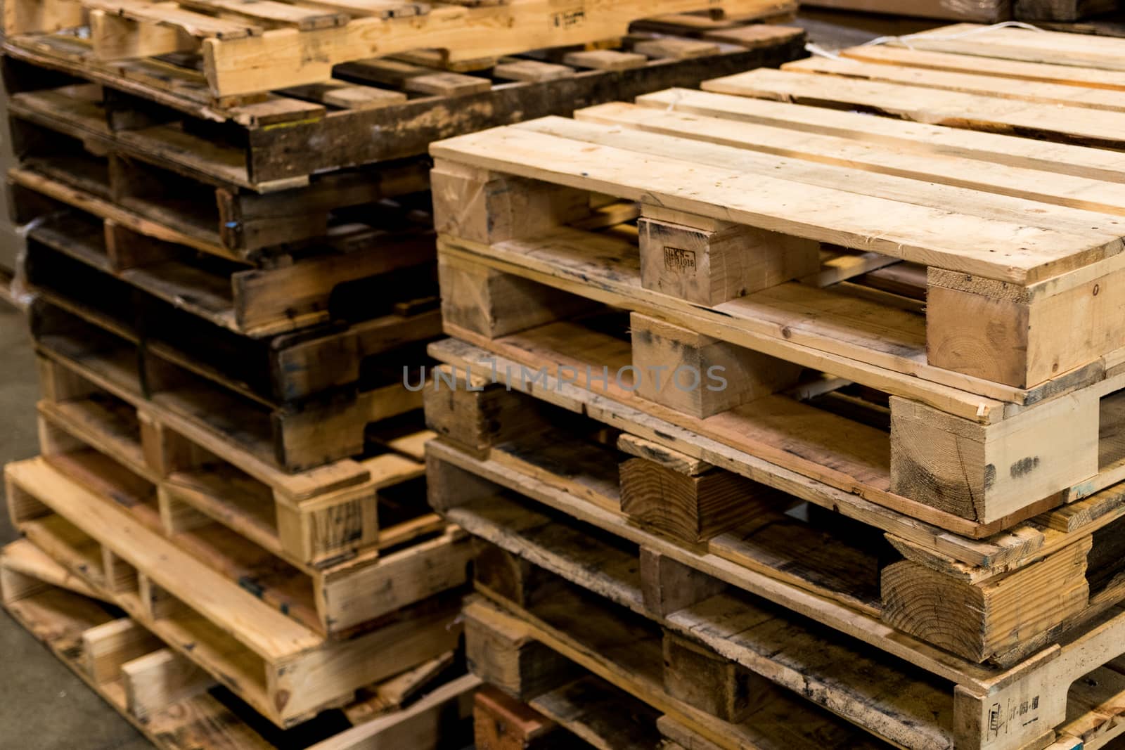 Used and new pallets stacked in rows cropped