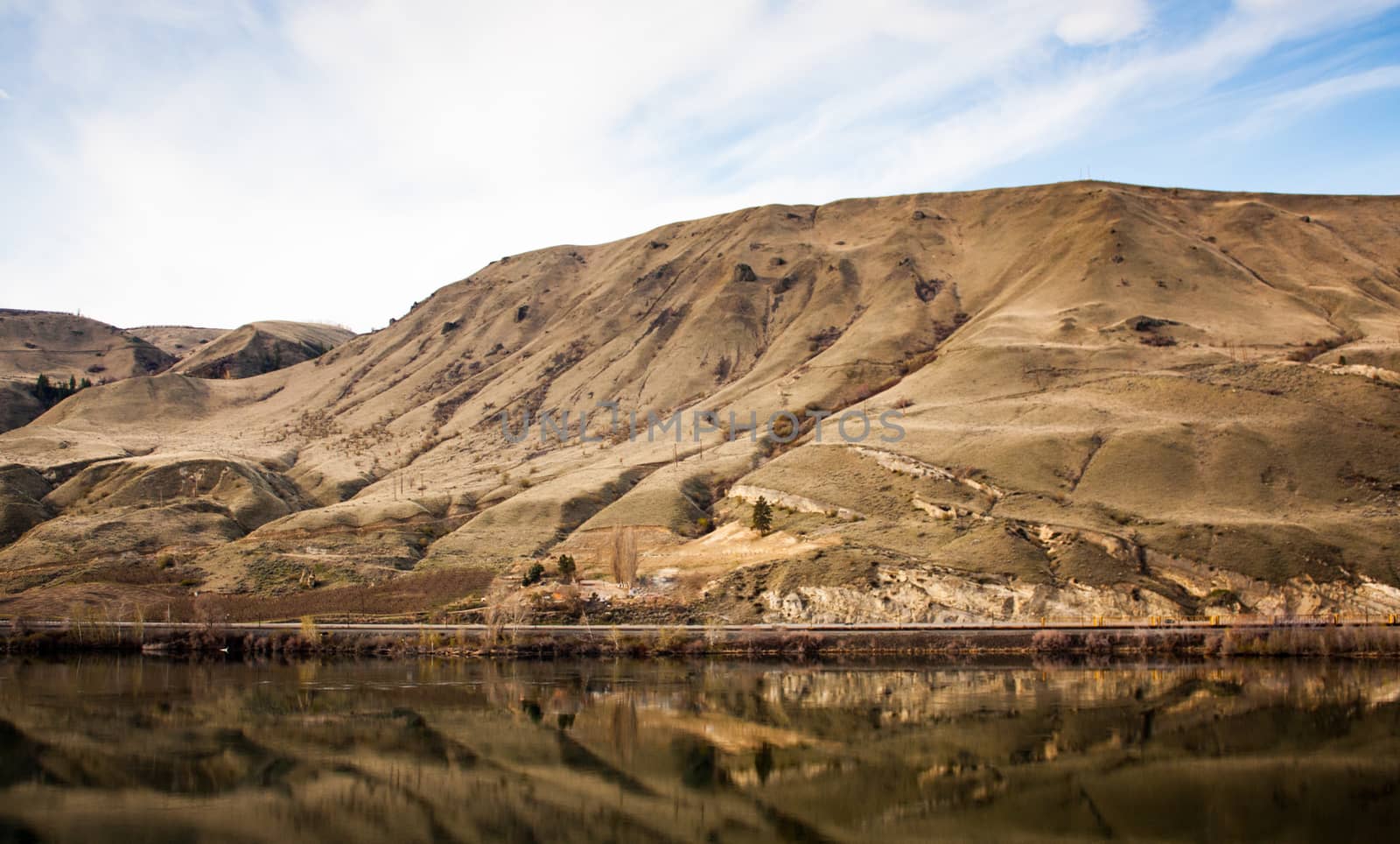 Golden desert canyon with reflection in river beneath